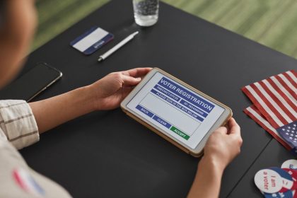 Pessoa utiliza um tablet em um posto de atendimento eleitoral.