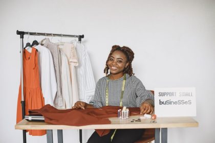Empreendedora sorrindo enquanto trabalha em seu estúdio de moda.
