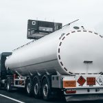 Caminhão-tanque transportando combustível por uma rodovia.
