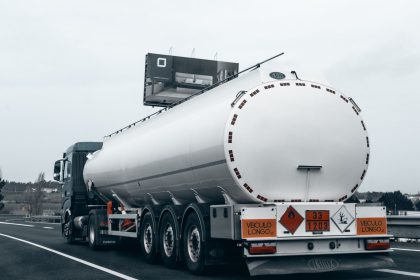 Caminhão-tanque transportando combustível por uma rodovia.